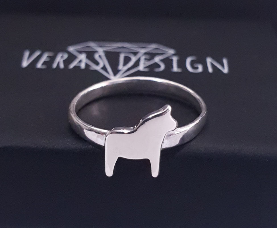 fingerring med dalahäst som ligger på en ask med texten veras design