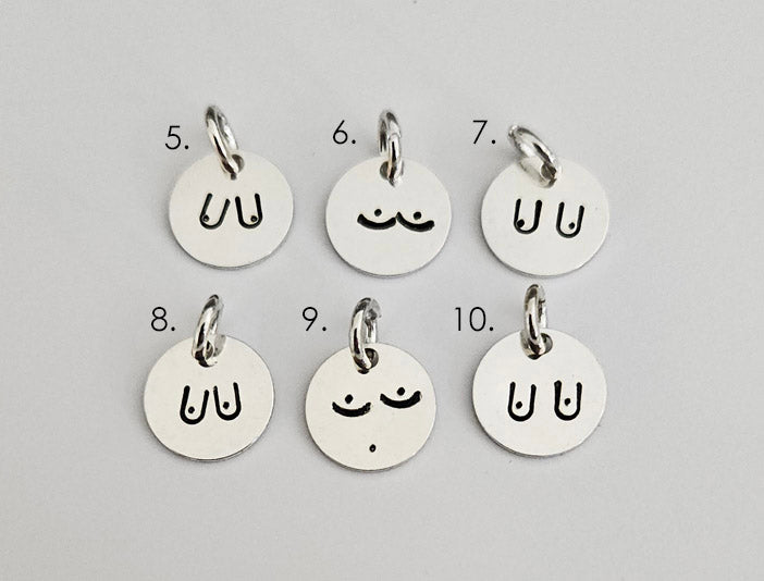 Bild på sex runda, handstämplade silverhängen med olika minimalistiska motiv av bröst. Berlockerna ligger på en ljus bakgrund och är numrerade från 5 till 10 för att visa de olika designvalen.